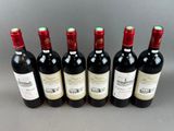 six bottles of wine are lined up in a row on a table