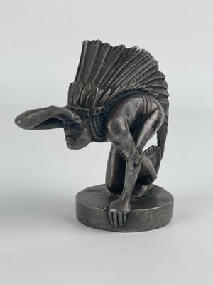statue d'un homme avec un éventail sur la tête, posée sur une surface blanche