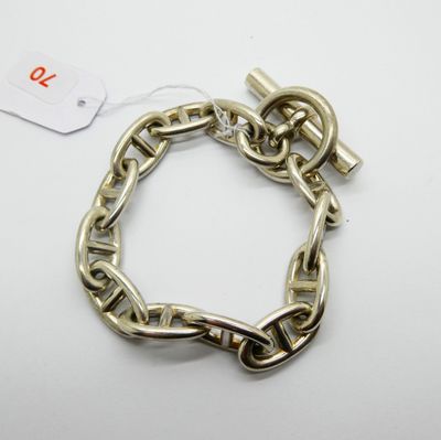 a close up of a chain bracelet with a tag on it