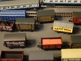 many toy trains on a table with other toy trains in the background