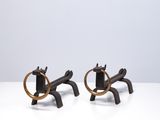 une paire de serre-livres en forme de chevaux, noirs et dorés, posés sur une table blanche
