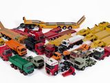 beaucoup de petits camions jouets posés sur une surface blanche