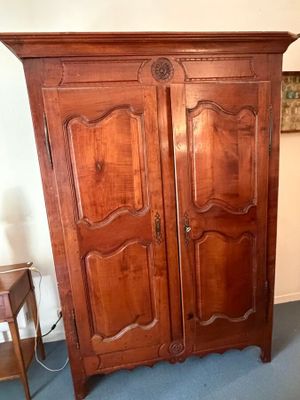 une grande armoire en bois surmontée de deux portes