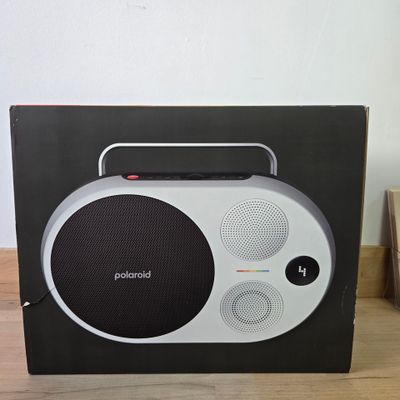 une radio en noir et blanc posée sur une table en bois