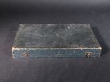 an old blue suitcase sitting on a black surface