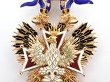 a gold and blue brooch with two birds on it
