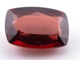 a red garnet stone on a white surface