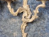 pair of antique wall sconces with candles on a blue background