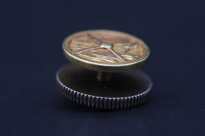 une pièce posée sur une autre pièce, sur une surface noire