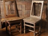 two wooden chairs sitting next to each other on a wooden floor