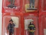 six firemen in plastic cases on a white surface