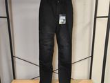 un jean noir accroché à un portant dans un magasin