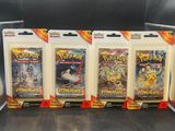 four packs of pokemon trading cards sitting on top of a table