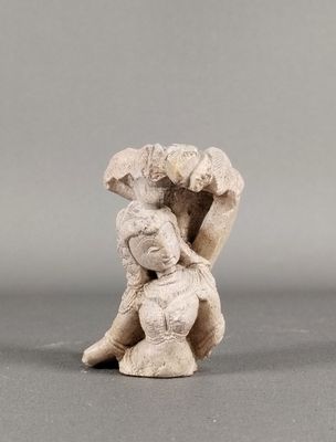 une vieille figurine représentant une femme tenant un parapluie au-dessus de sa tête
