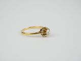 a close up of a gold ring with a diamond on it