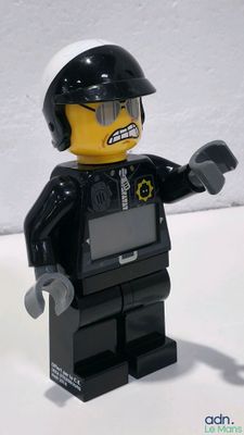 a lego man that is holding a gun in his hand