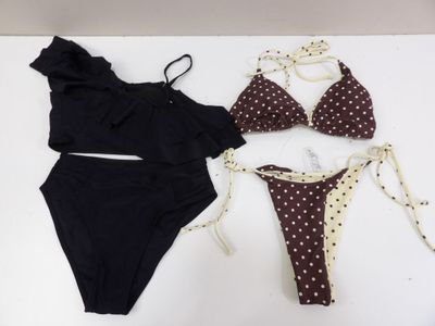deux bikinis et un maillot de bain posés sur une table