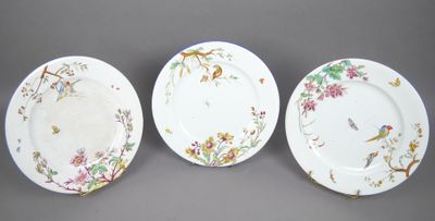 trois assiettes ornées d'oiseaux et de fleurs, posées sur une table