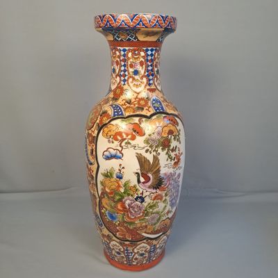 un vase avec un oiseau posé sur une table