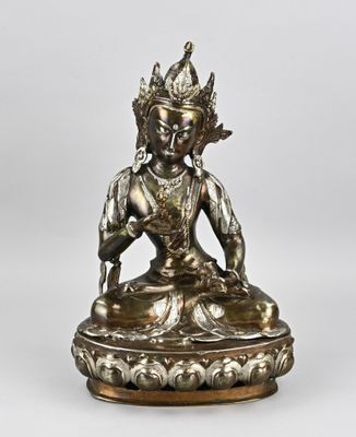 une statue en argent représentant une personne assise sur un lotus