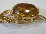 an image of a golden broochle on a white surface