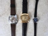 Trois types de montres différents sont alignés sur une table
