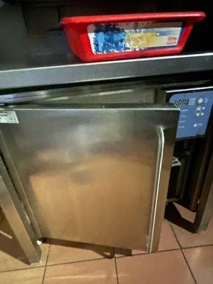 a stainless steel refrigerator in a kitchen with a red basket on top of it