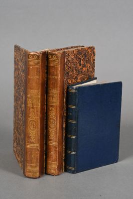 three books are stacked on top of each other on a gray surface