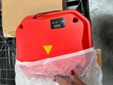 a person holding a red box with a yellow sticker on it