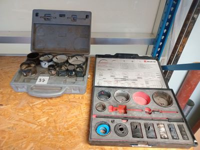 une trousse à outils posée par terre à côté d'une boîte à outils