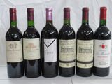 six bottles of wine are lined up in a row on a table