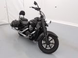une moto noire garée dans une pièce blanche