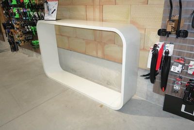 un comptoir blanc avec un plateau en verre dans un magasin