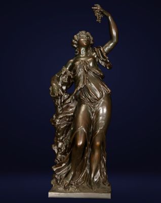 une statue en bronze représentant une femme tenant une fleur