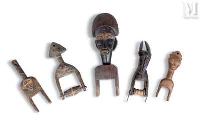 quatre figurines en bois de formes et de tailles différentes posées sur une surface blanche