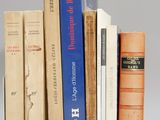 plusieurs livres sont empilés sur une surface blanche