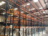 un grand entrepôt rempli de rayonnages et de palettes