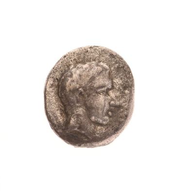 une vieille pièce de monnaie avec un visage d'homme sur une surface blanche