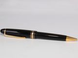 une image représentant un stylo noir et doré posé sur une surface blanche