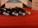 several bottles of wine are lined up on a red table cloth