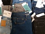 a lot of jeans that are stacked on top of each other