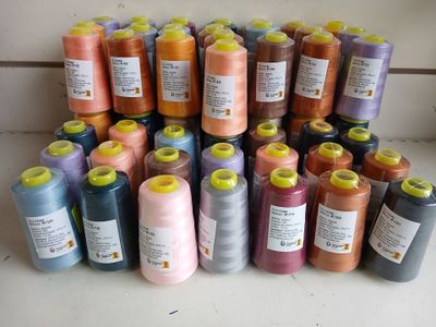 many spools of thread are arranged on a counter top