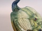a figurine of a peacock that is sitting on top of a table
