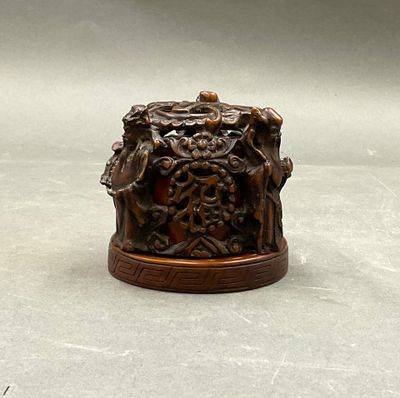 une petite boîte en bois ornée de sculptures, posée sur une table