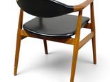a black chair with a wooden frame and black leather seat