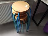 une pile de tabourets en bois posée à côté d'un radiateur