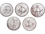 four coins with a drawing of a bird on them on a white surface