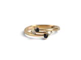 a close up of a gold ring with black and white diamonds