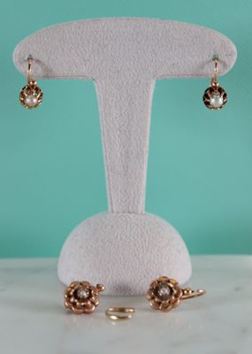 a close up of a pair of earrings on a display stand