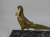 statue of a golden pheasant on a black marble base